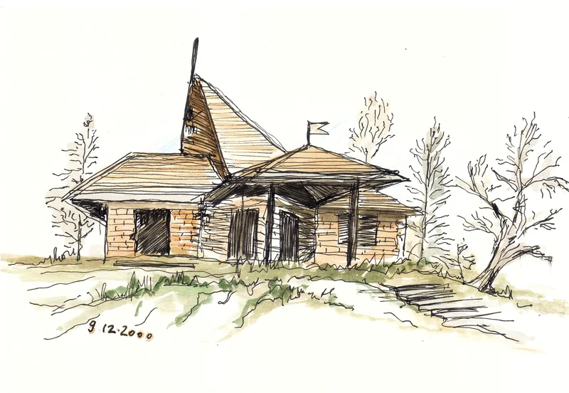 A low rural building with a sloping roof, pointed central feature, porch and steps.